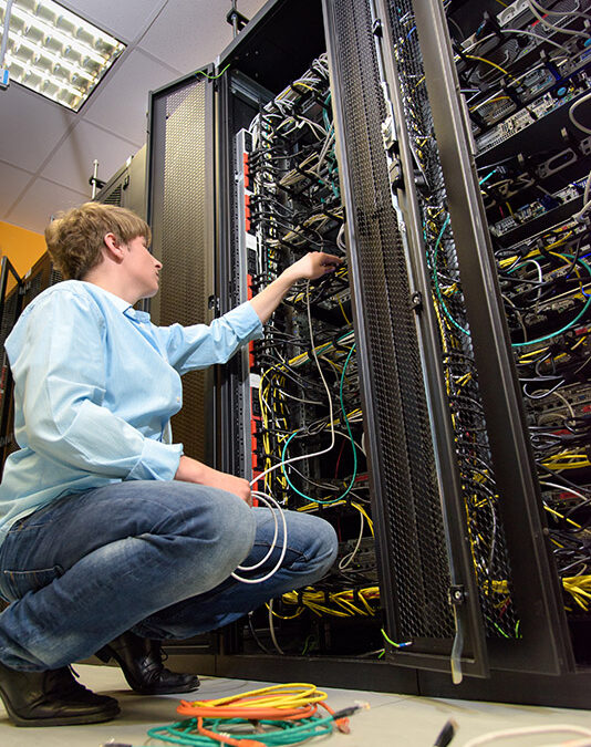 IT specialist installing cables in datacenter